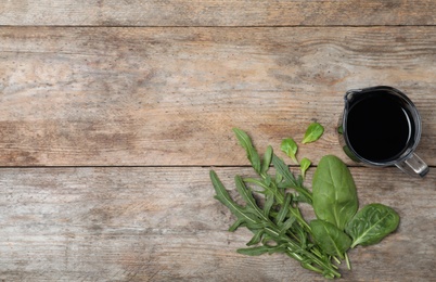 Flat lay composition with balsamic vinegar in pitcher and space for text on wooden background