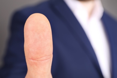 Photo of Man in office suit scanning fingerprint, closeup