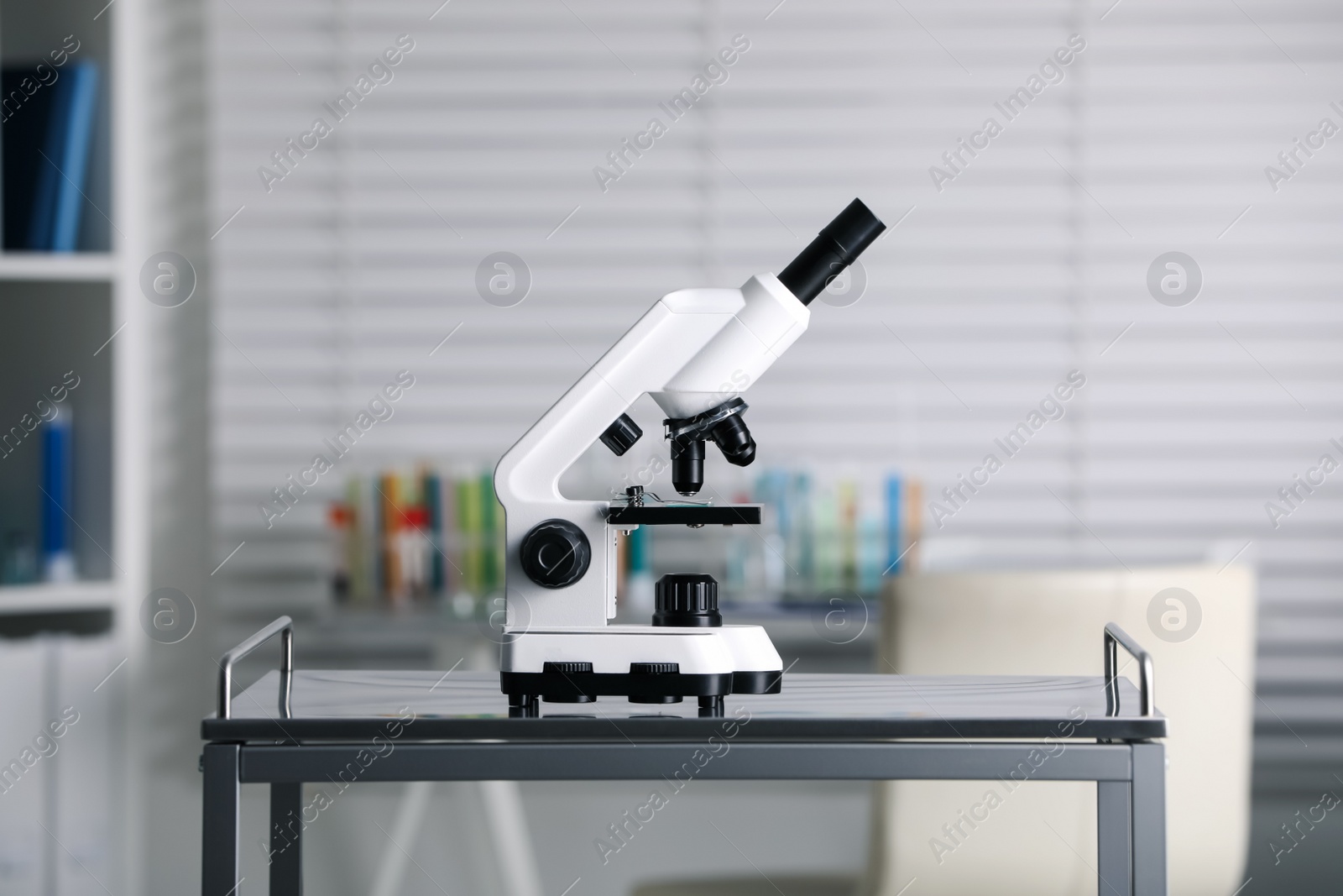 Photo of Modern medical microscope on metal table in laboratory