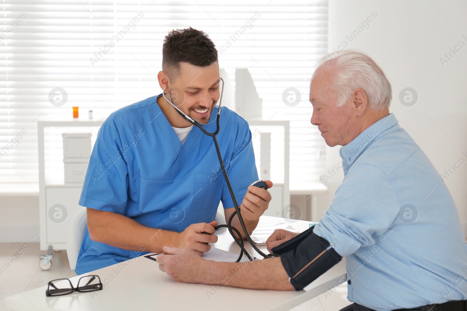 Photo of Doctor measuring blood pressure of senior patient in office