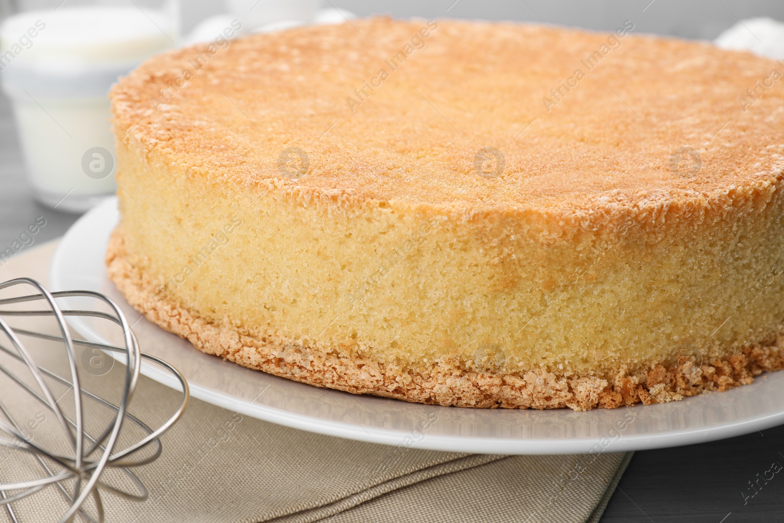 Photo of Plate with delicious sponge cake on table, closeup