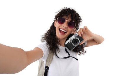 Beautiful woman in sunglasses with camera taking selfie on white background