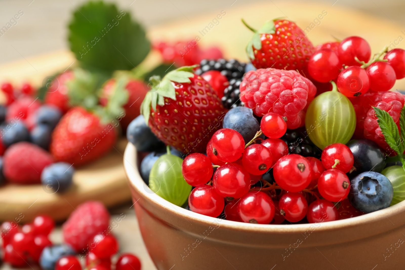 Photo of Mix of different fresh berries in bowl on table, closeup