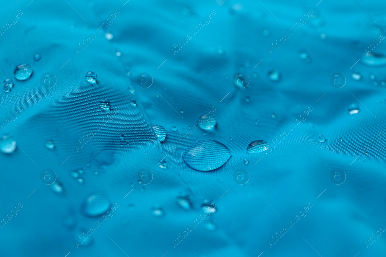 Photo of Light blue waterproof fabric with water drops as background, closeup