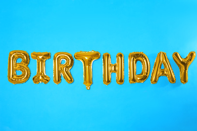 Photo of Word BIRTHDAY made of foil balloon letters on light blue background