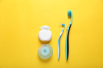 Photo of Flat lay composition with dental floss and different teeth care products on yellow background