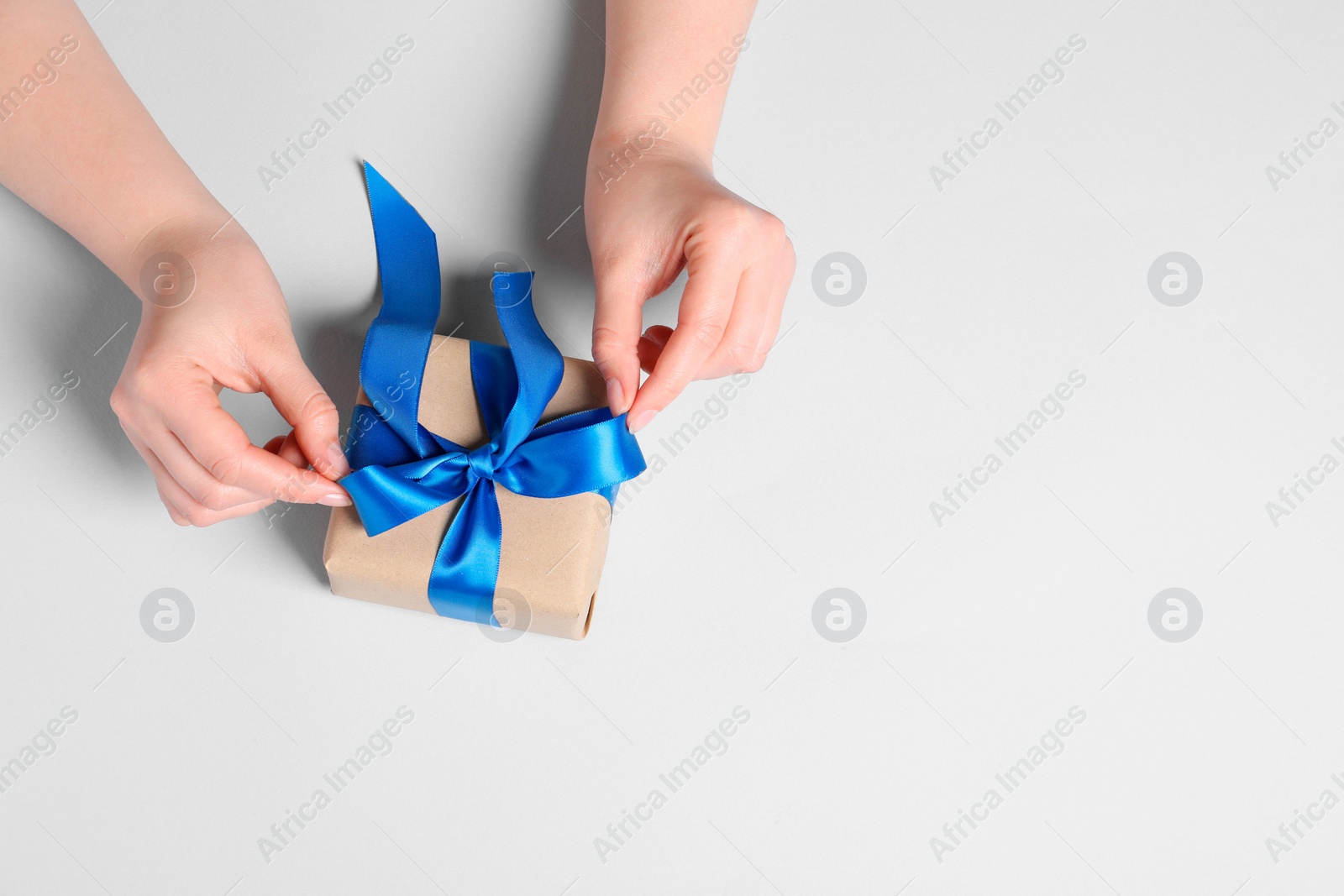 Photo of Woman with gift box on white background, top view. Space for text