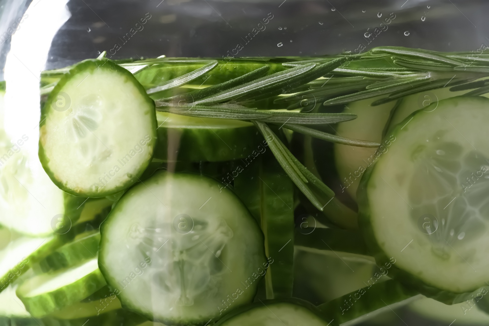 Photo of Large jar of fresh cucumber water with rosemary, closeup