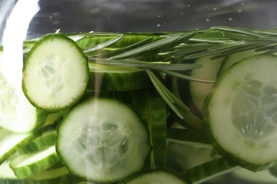 Large jar of fresh cucumber water with rosemary, closeup