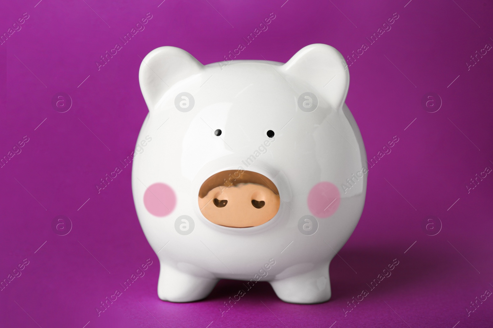 Photo of Ceramic piggy bank on purple background. Financial savings