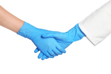 Photo of Doctors shacking hands in medical gloves on white background