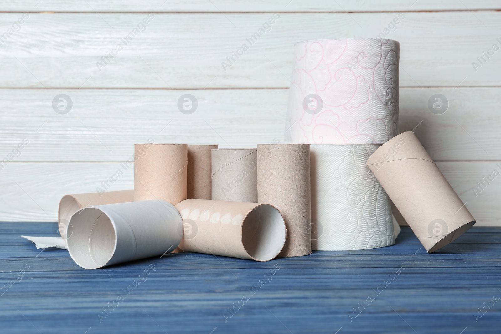 Photo of Full and empty toilet paper rolls on table against white background