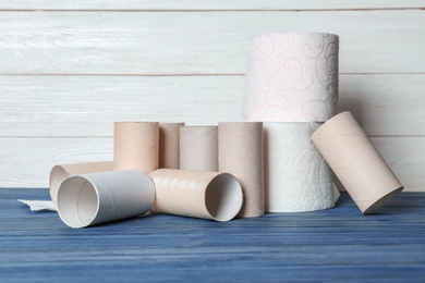 Full and empty toilet paper rolls on table against white background