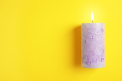 Alight wax candle and space for text on color background