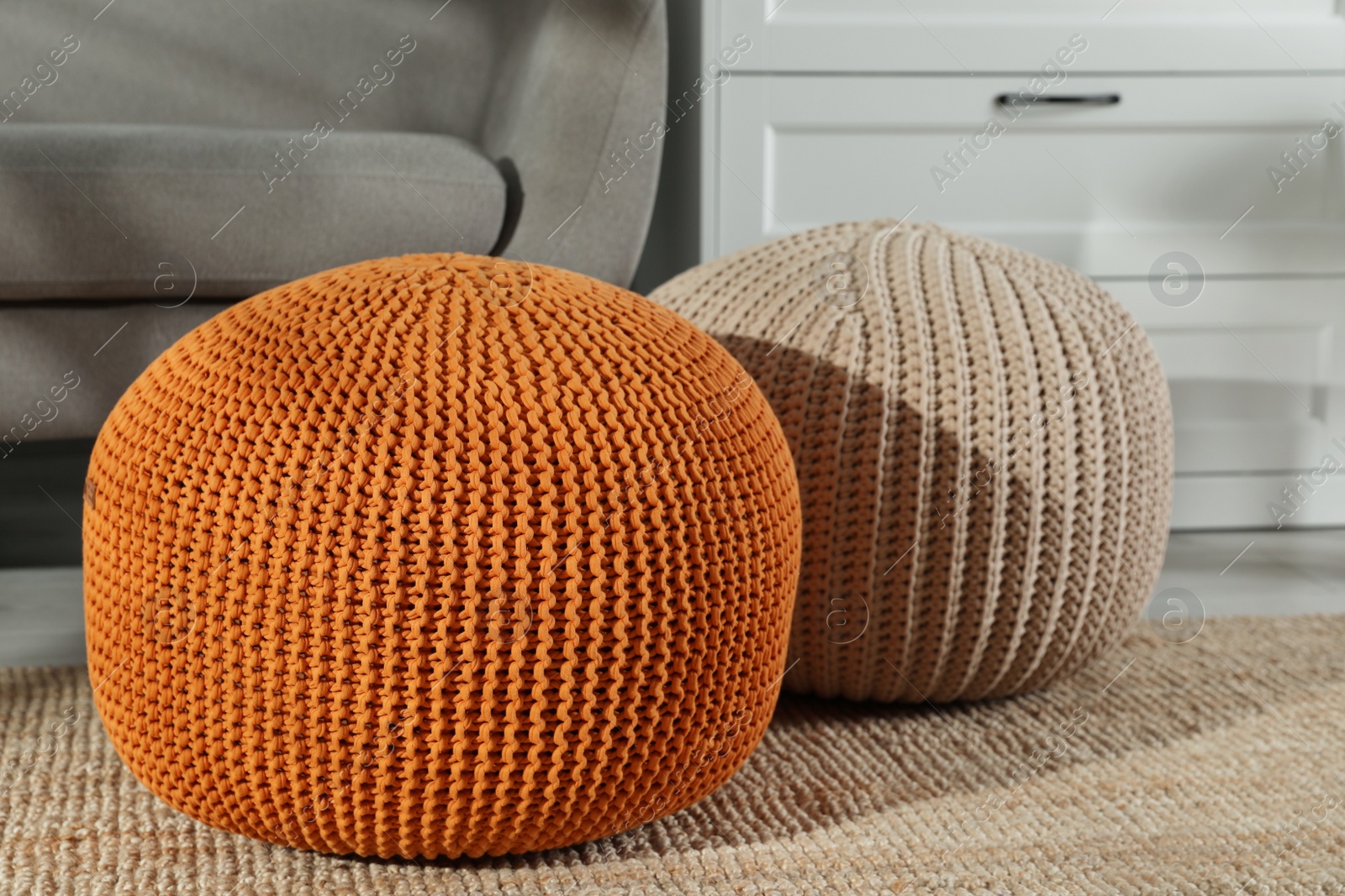 Photo of Stylish knitted poufs and sofa in living room. Home design