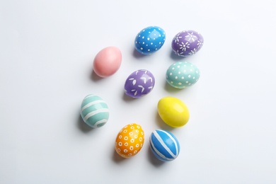 Composition of painted Easter eggs on white background, top view