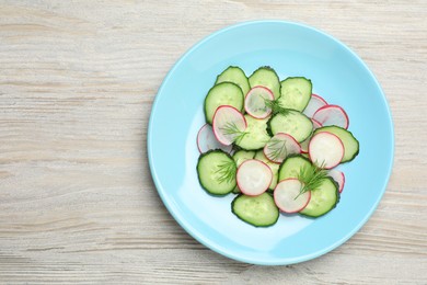 Photo of Tasty salad with cucumber and radish on wooden table, top view. Space for text