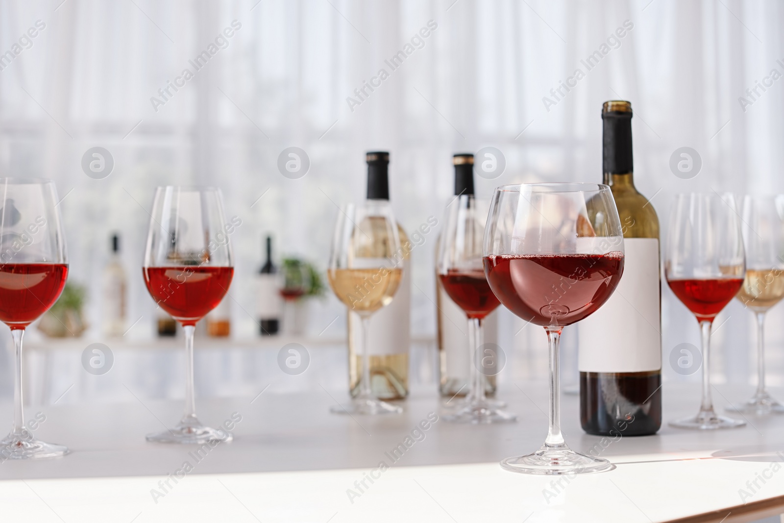 Photo of Glasses and bottles with delicious wine on table indoors