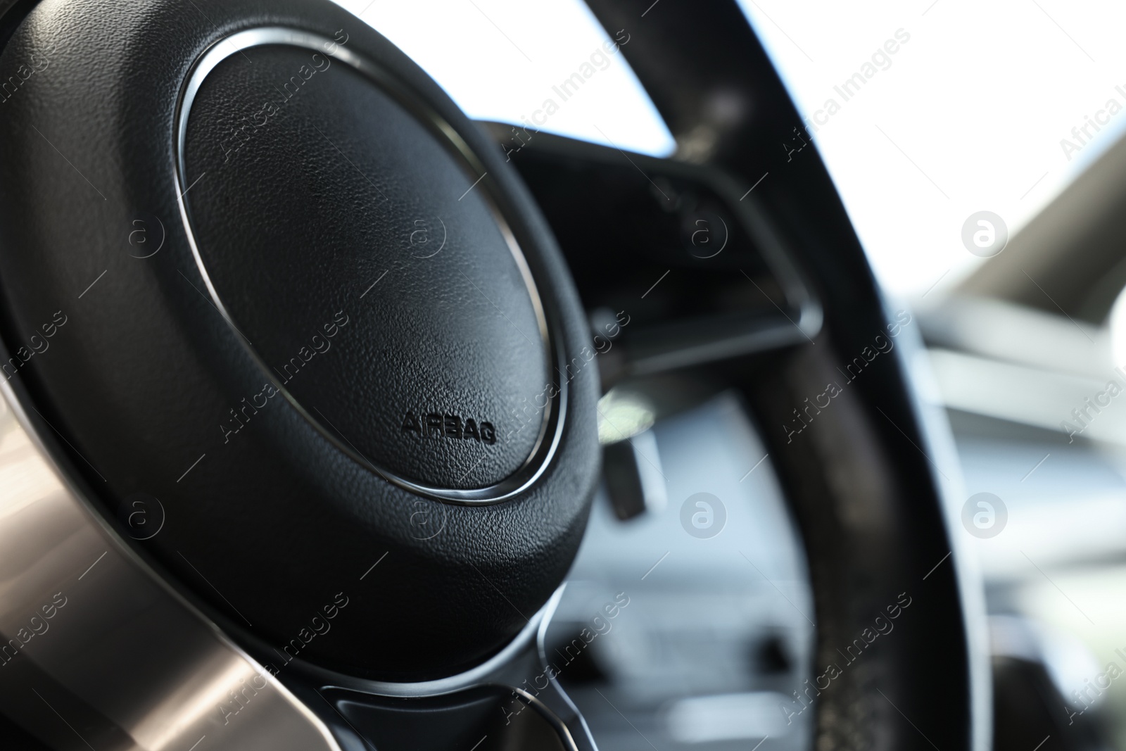 Photo of Steering wheel inside of black modern car, closeup