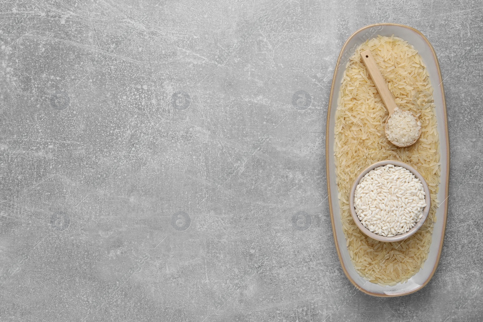 Photo of Different sorts of rice on grey table, top view. Space for text