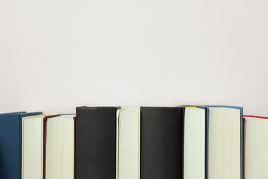 Photo of Different hardcover books on white background. Space for text