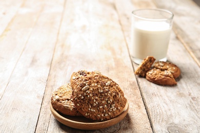 Photo of Plate with grain cereal cookies on wooden table. Healthy snack