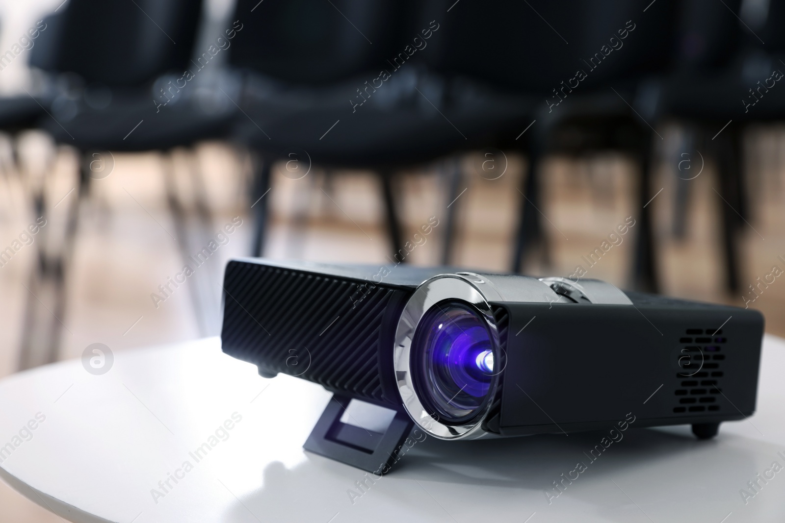 Photo of Modern video projector on table in conference room