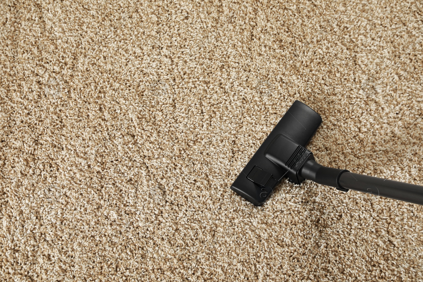 Photo of Removing dirt from beige carpet with modern vacuum cleaner, above view. Space for text