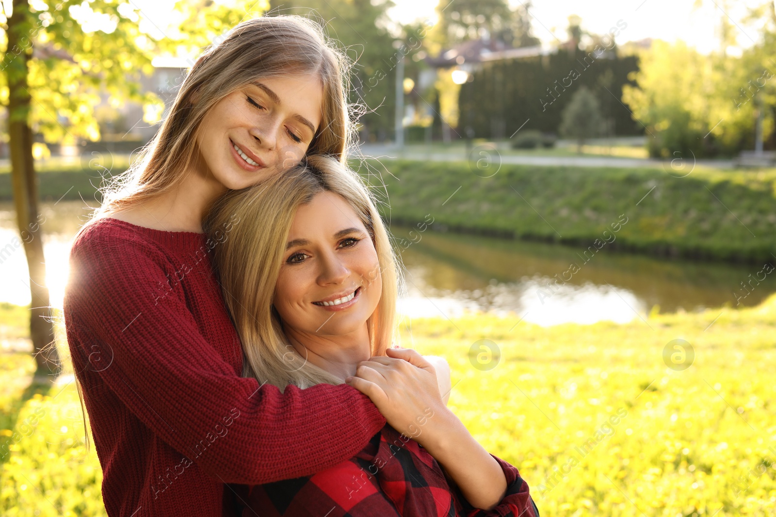 Photo of Happy mother with her daughter spending time together in park on sunny day