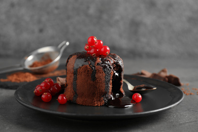 Delicious warm chocolate lava cake with berries on grey table