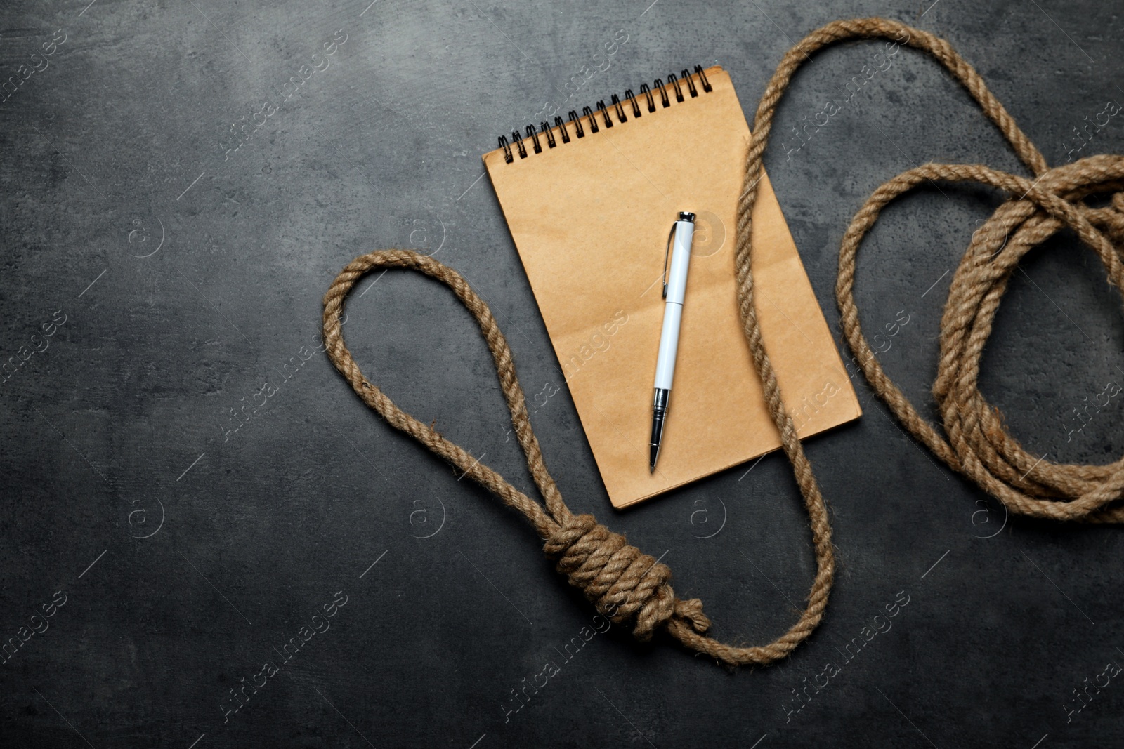 Photo of Rope noose and blank notebook with pen on grey table, flat lay