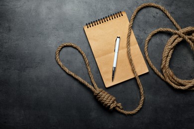 Photo of Rope noose and blank notebook with pen on grey table, flat lay