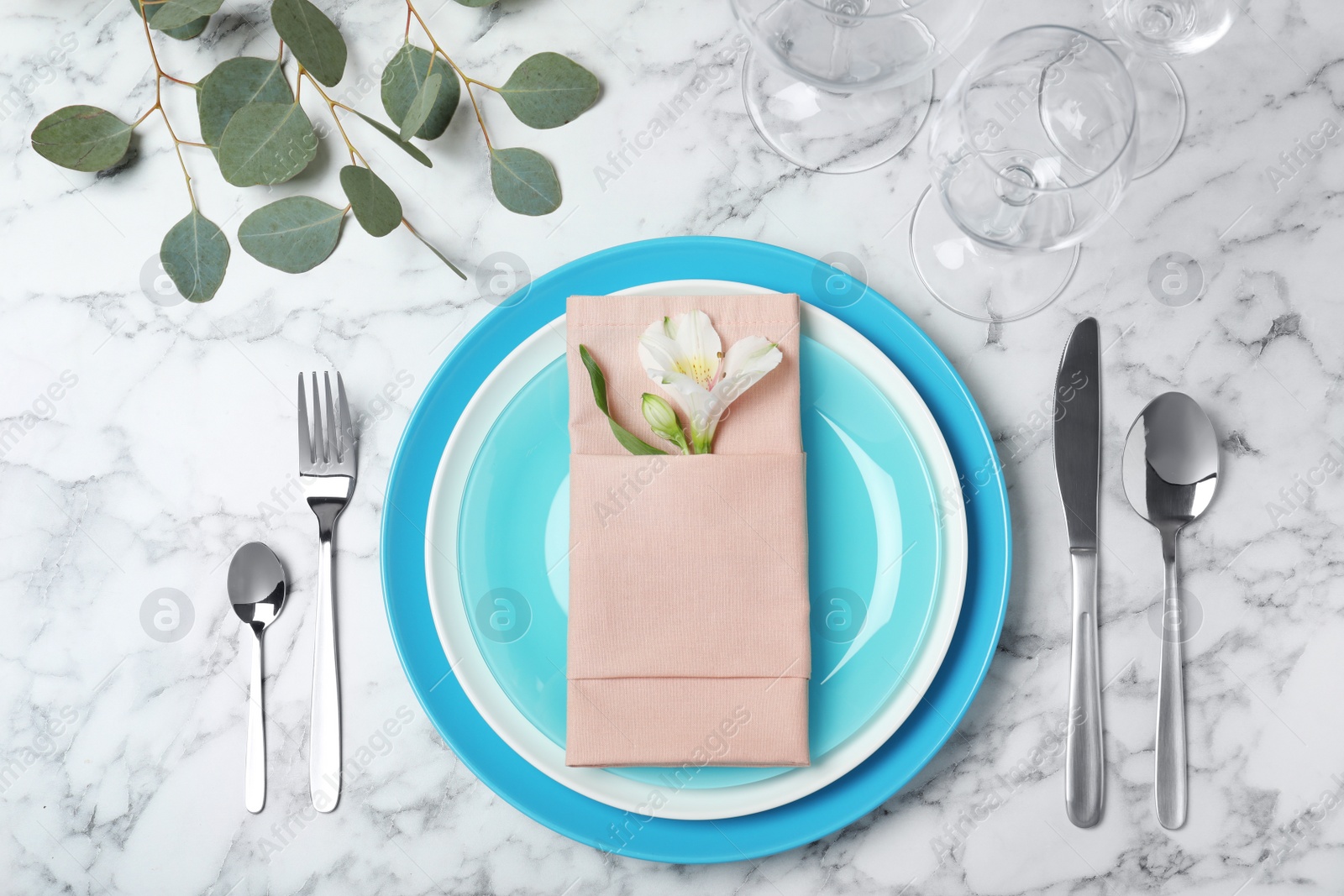 Photo of Beautiful table setting with cutlery, glasses, napkin and plates on marble background, top view