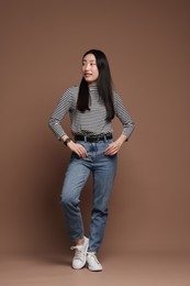 Photo of Full length portrait of smiling woman on brown background