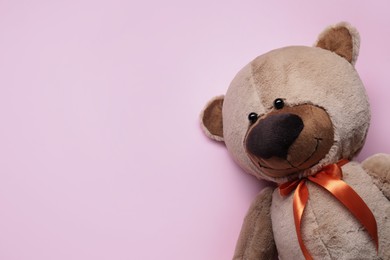 Photo of Cute teddy bear on pink background, top view. Space for text