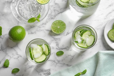 Flat lay composition with glasses of cucumber water on table