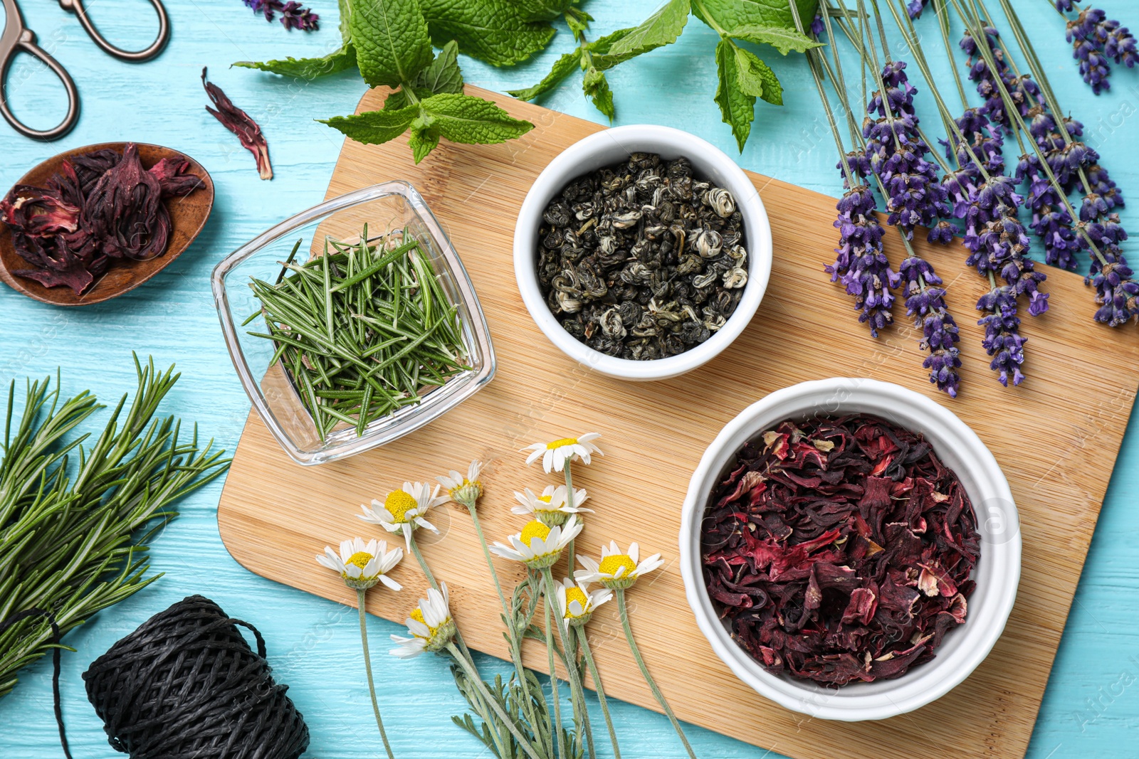 Photo of Flat lay composition with healing herbs on light blue wooden table