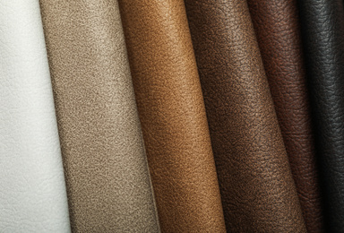 Different leather samples as background, closeup view