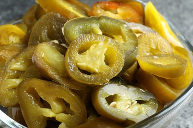 Glass bowl with slices of pickled green jalapeno peppers, closeup