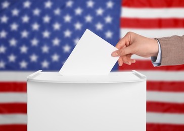 Election in USA. Woman putting her vote into ballot box against national flag of United States, closeup