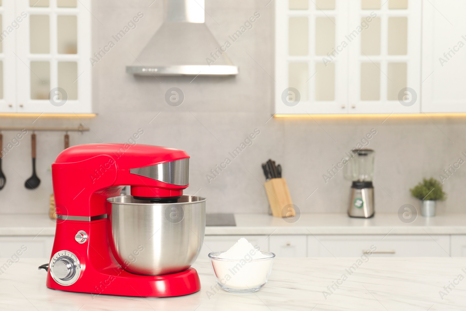 Photo of Modern red stand mixer and bowl with flour on white marble table in kitchen, space for text