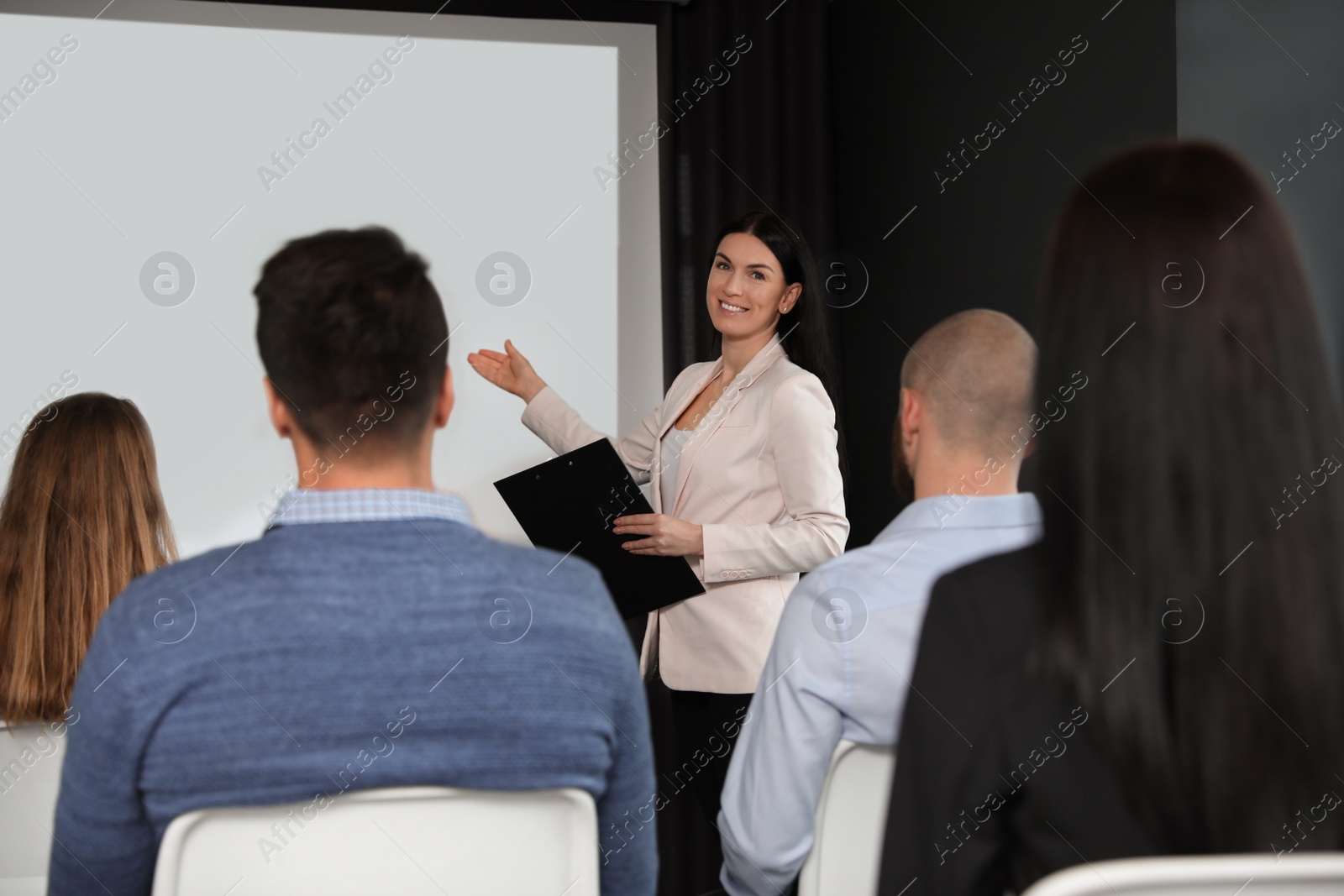 Photo of Business people at seminar in conference room with video projection screen