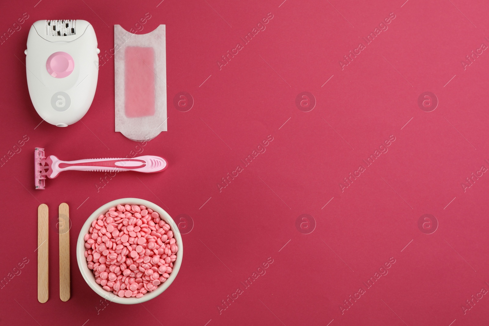 Photo of Set of epilation products on crimson background, flat lay. Space for text