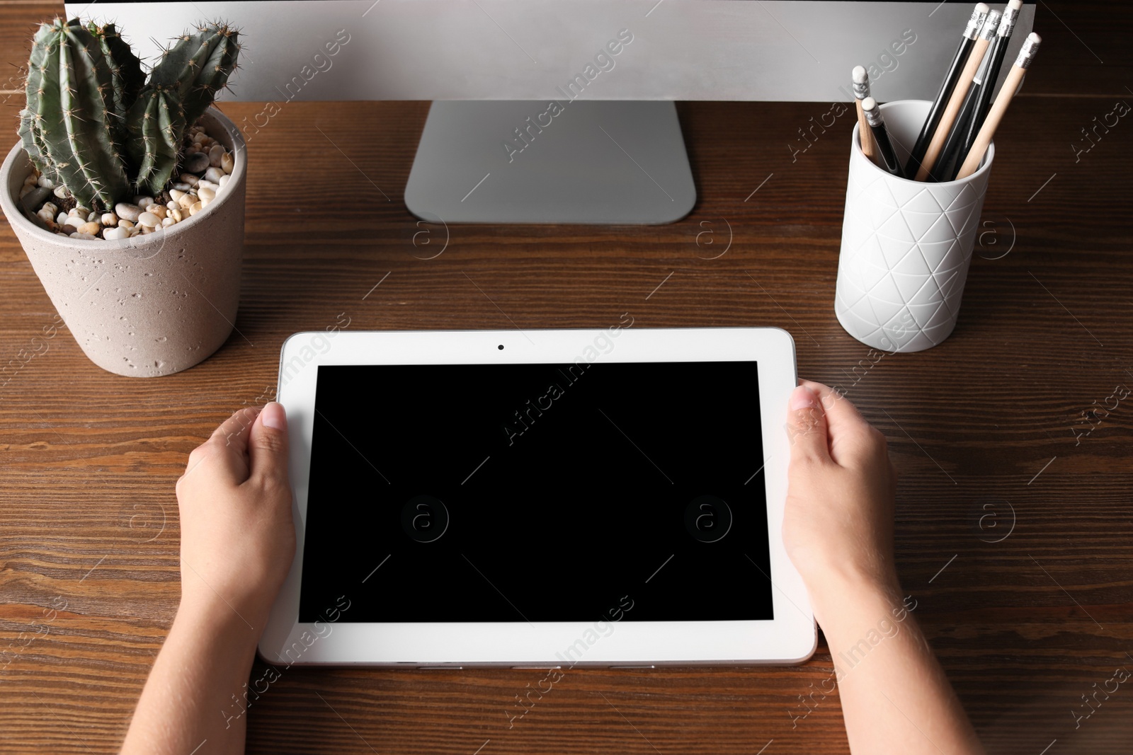 Photo of Woman holding tablet with blank screen at table. Mockup for design