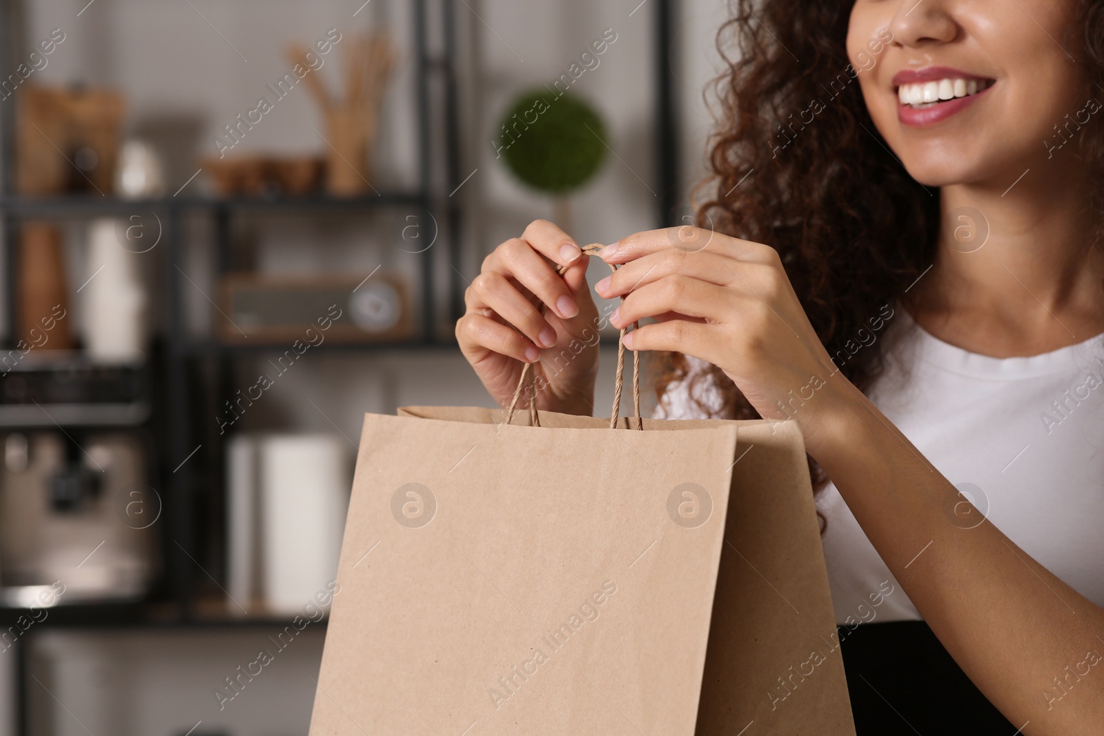 Photo of African American woman with paper bag indoors, closeup