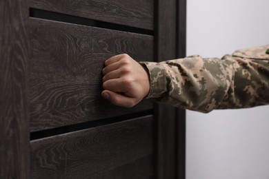 Photo of Military commissariat representative knocking on wooden door, closeup