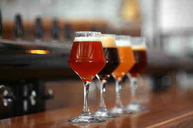 Different beers in glasses on bar counter