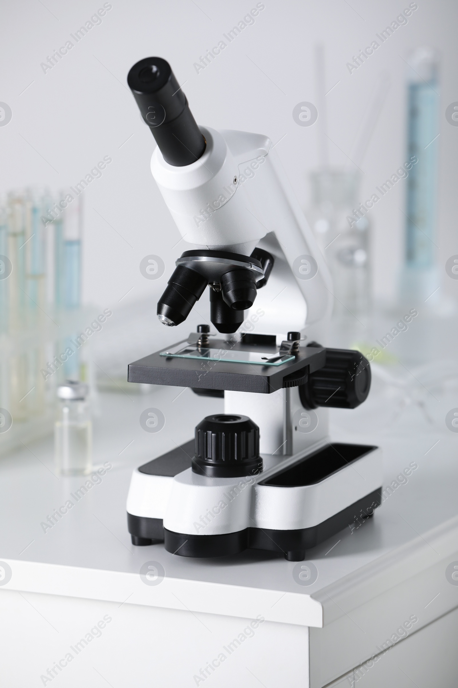 Photo of Modern medical microscope on white table in laboratory