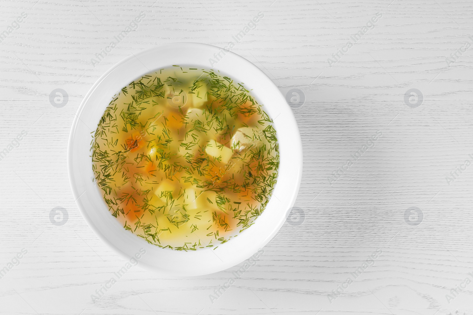 Photo of Bowl of fresh homemade soup to cure flu on wooden background, top view with space for text