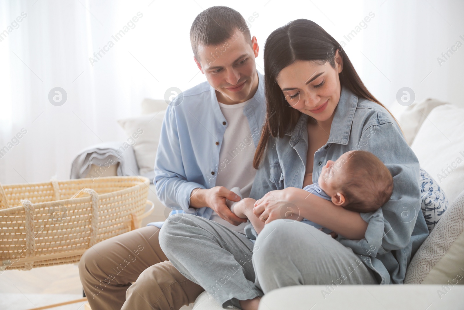 Photo of Happy family with cute baby on sofa at home